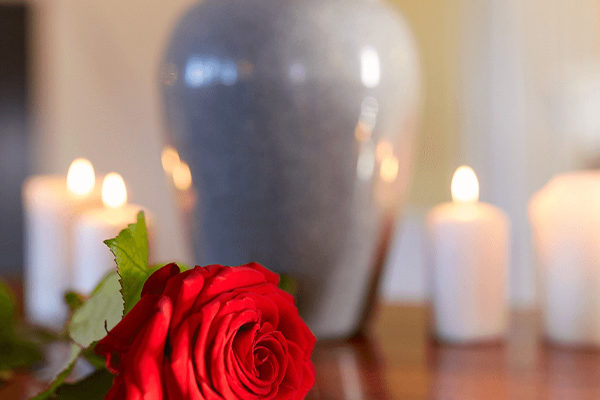 Urn with lit candles and rose